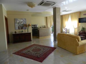 a living room with a couch and a kitchen at Hotel Le Palme in Gioia Tauro