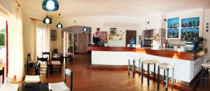 un restaurante con bar, mesas y sillas en Hotel Mirage, en Santa Teresa Gallura