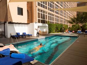 a man in a swimming pool in a building at Arabian Courtyard Hotel & Spa in Dubai