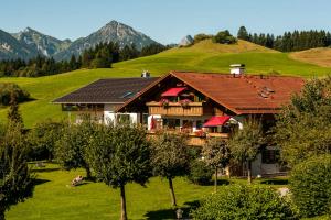 a house on a hill with mountains in the background at Allgäu-Moni in Füssen