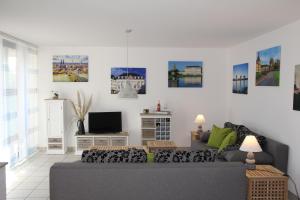 a living room with a couch and a tv at Apartment-Koeln-Bonn, Ihr Zuhause auf Zeit. in Wesseling