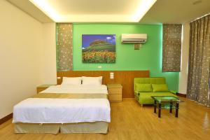 een slaapkamer met een bed en een groene muur bij Chang Cheng Min Su in Magong