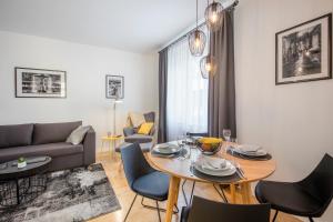 a living room with a table and chairs and a couch at Apartments N10 Zagreb in Zagreb