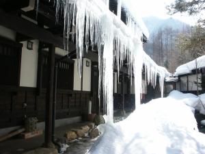 um edifício com gelo pendurado do lado em Katsuragi no Sato em Takayama