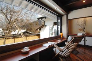 a room with a desk and a large window at Katsuragi no Sato in Takayama