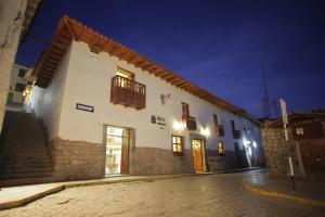 a large white building on a street at night at Siete Ventanas in Cusco