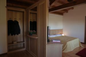ein Schlafzimmer mit einem Bett und einem TV in einem Zimmer in der Unterkunft B&B Villa Carli in Caneva