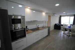 uma cozinha com electrodomésticos de aço inoxidável e uma sala de jantar em Bellavista apartment em El Campello