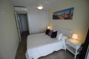 - une petite chambre avec un lit blanc et des oreillers dans l'établissement Bellavista apartment, à El Campello