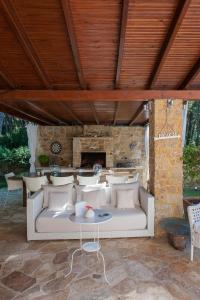 a living room with a white couch and a fireplace at Naftilos Villa Sani in Sani Beach