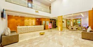 a lobby with couches and chairs and a reception desk at RG Hotels and Resort in Mālūr