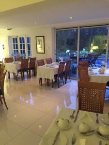 uma sala de jantar com mesas e cadeiras e uma grande janela em Norfolk House em Maidenhead