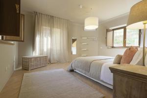 a white bedroom with a bed and a window at B&B Palazzo Bibirria in Agrigento