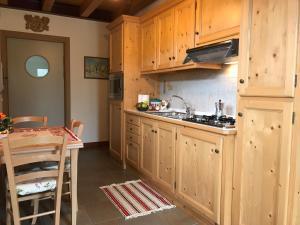 a kitchen with wooden cabinets and a sink and a table at Puffele b&b in Enego