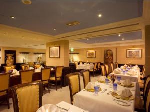 a restaurant with white tables and chairs and tablesearcher at Arabian Courtyard Hotel & Spa in Dubai