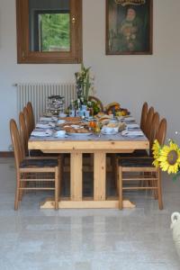 una mesa de madera con sillas alrededor con comida. en B&B Villa Carli, en Caneva