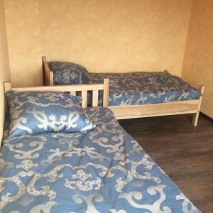 Ryškėnai的住宿－Svečių namai，一间卧室配有两张带蓝白色床单的床
