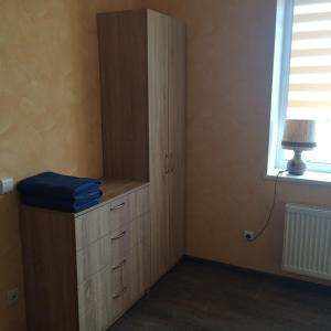 ein Schlafzimmer mit einer Kommode und einem Fenster in der Unterkunft Svečių namai in Ryškėnai