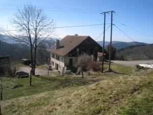 a house sitting on top of a hill next to a road at gites Les Bleuets in Vagney