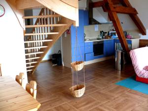 a living room with a staircase and a kitchen at gites Les Bleuets in Vagney