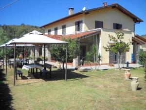 una casa con mesa de picnic y sombrilla en Locanda Contrada dei Fattori, en Cairo Montenotte