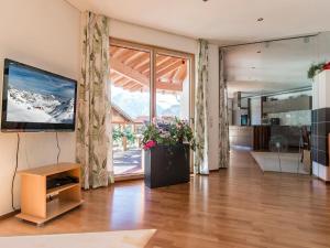 ein Wohnzimmer mit einem TV und einem großen Fenster in der Unterkunft Ferienwohnung Lifinar in Schruns-Tschagguns