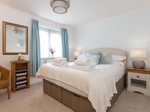 1 dormitorio con 1 cama grande y toallas. en Sandpiper, en Poole