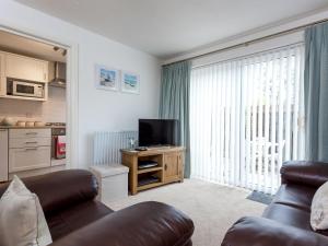 a living room with a couch and a large window at Sandpiper in Poole