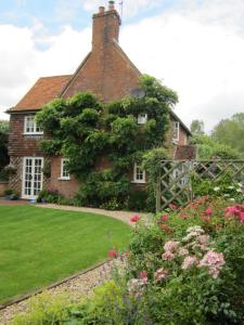 ein Backsteinhaus mit Garten davor in der Unterkunft Vine Cottage in Farnham