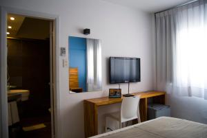 Uma TV ou centro de entretenimento em Hotel Florinda