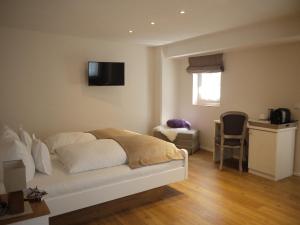 a bedroom with a bed and a television on the wall at Hotel Ratsstuben in Lindau