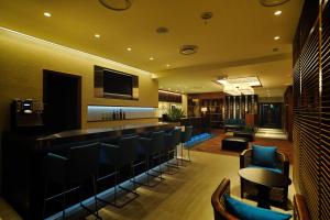 - un bar dans une salle d'hôtel avec des chaises et un comptoir dans l'établissement Fukuyama Plaza Hotel, à Fukuyama