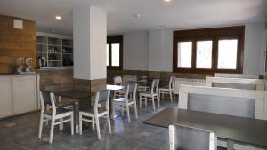 a restaurant with tables and chairs and a bar at Hotel Rural El Nido de Pinares in Navaleno