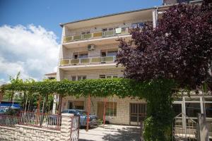 a building with a tree in front of it at Apartment Suzana in Stobreč