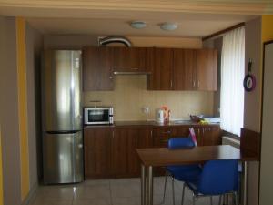 Una cocina con refrigerador de acero inoxidable y una mesa. en Warneńczyka 85A bezpłatny parking, faktura, prywatna łazienka, klimatyzacja, en Rzeszów