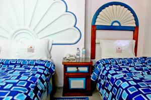 - une chambre avec 2 lits et une table avec une table de chevet dans l'établissement Hotel El Refugio, à Tlaxcala de Xicohténcatl