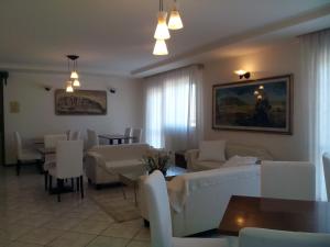 a living room with white couches and tables and chairs at Hotel Gasperoni in San Marino