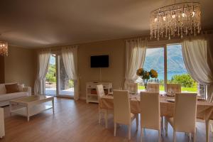 a dining room with a table and a chandelier at Ville Mirage in Tremezzo