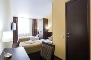 エカテリンブルクにあるVash Hotelのベッド2台とテーブルが備わるホテルルームです。