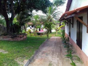 a house with a path next to a yard with trees at Pousada Mirage Atins in Atins
