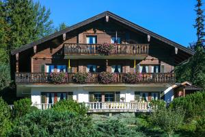 a large wooden house with balconies and flowers at Gästehaus Lipp in Mittenwald