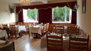 una sala da pranzo con tavoli e sedie e una finestra di Divine Mercy B&B a Knock