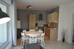 a kitchen and dining room with a table and chairs at Apartamenty Willa Nawigator in Gdynia