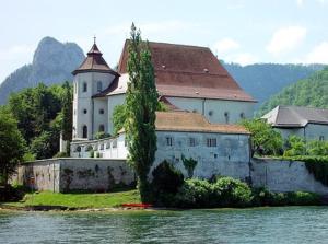 a large building on the edge of a body of water at Ferienhaus Schiemel in Altmünster