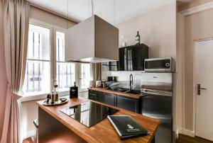 cocina con nevera de acero inoxidable y encimera en Appartements Cathédrale - YBH, en Burdeos