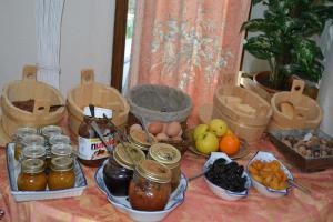a table with jars of food and fruits on it at Logis Hôtel Le Vieil Amandier in Trigance +17 photos