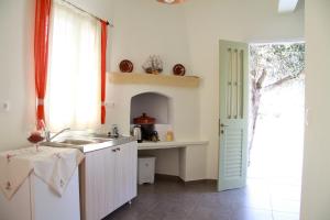une cuisine blanche avec un évier et une fenêtre dans l'établissement Aggelis Villa, à Artemonas
