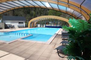 una gran piscina con un arco sobre ella en Camping La Clé des Champs en Saint-Nectaire