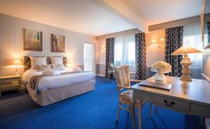 a hotel room with a bed and a desk and a desk at Best Western Plus Hostellerie Du Vallon in Trouville-sur-Mer