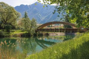 un puente sobre un río con montañas en el fondo en Le Dolcezze, en Crone